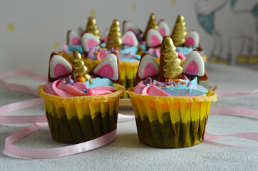 Beautiful delicious multicolored cupcakes for children's holiday table in the style of a unicorn