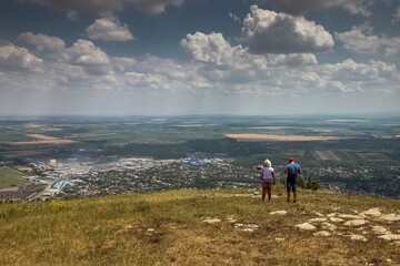 Obraz premium Two tourists enjoy the beautiful view of Pyatigorsk city from Mashuk mountain. Russia. Nice summer day.