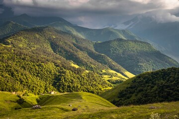 Obraz premium Terrific view of the green Caucasus mountains under heavy clouds and slopes covered with endless forests. Russia.