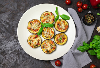 Baked eggplant on a plate. Black background. Free space for your text. Top view.
