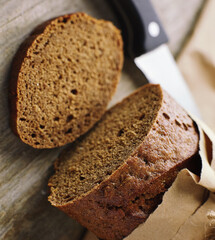 A loaf of Bread packed in paper on wooden table