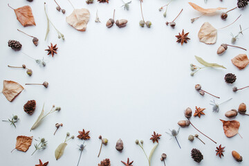 Autumn vibes. Pattern made of dried leaves, acorns and pine cones on white background. Seasonal...
