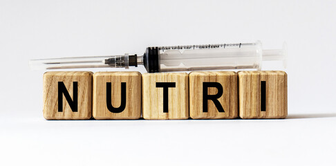 Text NUTRI made from wooden cubes. White background
