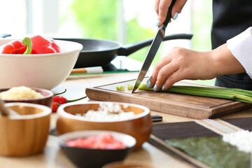 Beautiful Asian chef cooking in kitchen, closeup