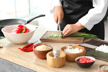 Beautiful Asian chef cooking in kitchen, closeup