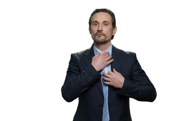 Businessman adjusting tie with right hand. Confident corporate man isolated on white background.