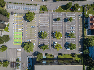Aerial view of large almost empty car parking on sunny summer day.