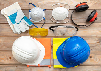 Work safety protection equipment on wooden background.