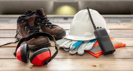 Work safety protection equipment. Industrial protective gear on wooden table, blur construction...