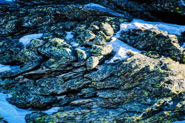 Mountain stone at very high altitude with no plant covered only with snow during sunny winter day.