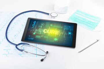 Tablet pc and medical stuff with CURE inscription, prevention concept