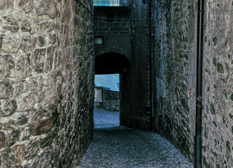 Obraz premium Narrow and dark street during cold winter morning in Bormio, Italy.