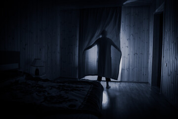 Horror woman in window wood hand hold cage scary scene halloween concept Blurred silhouette of...