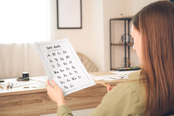 Female calligraphist working in office