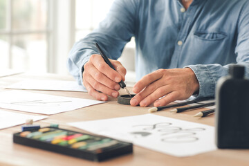 Fototapeta premium Senior male calligraphist working in office, closeup