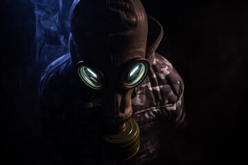 Gas mask with clouds of smoke on a dark background. Sign of radioactive contamination. Means for...