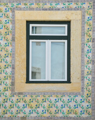Typical portuguese window with ornamental tiles called "azulejos", made with colored ceramic tiles, in Lisbon, Portugal