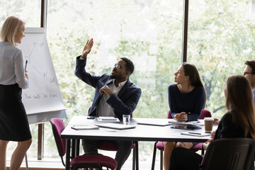 60s trainer gives presentation use flip chart interact with corporate staff participating at...