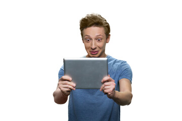 Surprised caucasian guy is looking at his tablet pc. Isolated on white background.