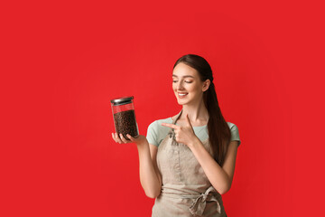 Young female barista on color background