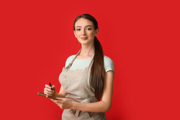 Young female barista on color background