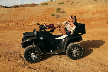Fototapeta na wymiar beautiful sexy woman with dark hair in casual clothes and accessories posing in desert with safari car