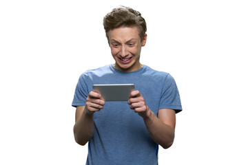 Teenage boy's looking at his smartphone angrily. Rage and stress while holding a phone. Isolated on white.