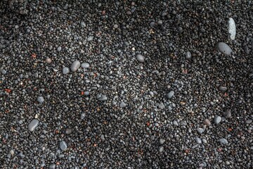 Black lava pebble, small stones of hardened lava at Reynisfjara Black Sand Beach .