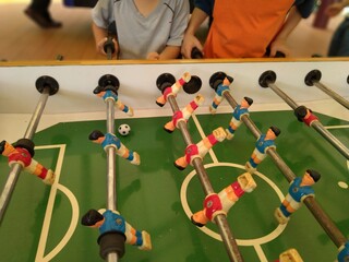 the family members are playing the Football table for fun
