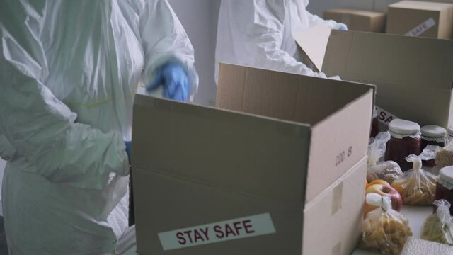 Food online shopping delivery,workers in protective suit pack food goods into a box with a stay safe label on it