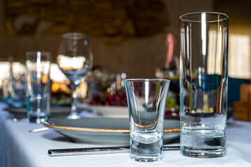 Table setting. Cutlery. Glass, stack, bowls and fork on the table.