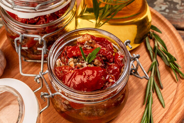 Dried tomato with olive oil and herbs in a glass jar