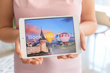 Woman with tablet computer booking tickets online at home
