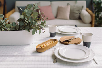 Elegant crockery and decor on table in modern dining room. Table set for family dinner.