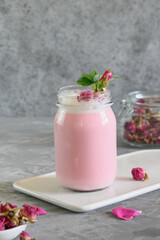 Rose moon milk in mason jar on grey background. Close up. Ayurveda warm drink. Nice in case of sleeplessness.