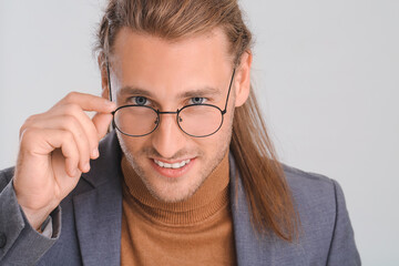 Fototapeta premium Handsome man with stylish hairdo on light background