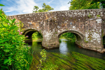 Fototapeta premium Woolbeding Bridge a medieval bridge over the River Rother in the South Downs National Park, near Midhurst West Sussex. Restored in 1919, there are less than 200 multispan medieval bridges in England.