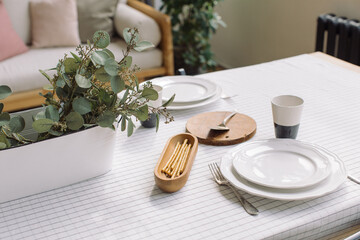 Elegant crockery and decor on table in modern dining room. Table set for family dinner.