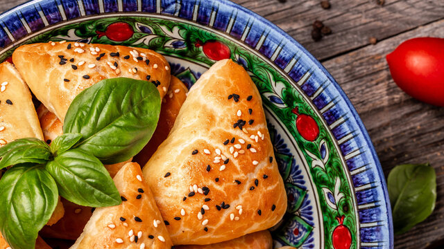 Samosas, oriental uzbek cuisine, Central Asian cuisine. samsa with chicken and sprinkled with sesame seeds, samosa on a wooden board, Long banner format