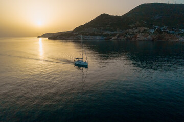 Sailboat in the sea in the evening sunlight over beautiful big mountains background, summer adventure, active vacation in Mediterranean sea, Turkey