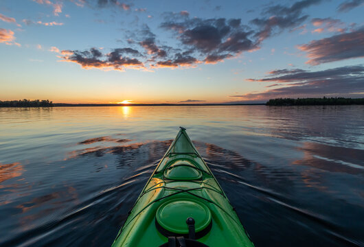Kayaking at sunset on a calm lake in Northwest Ontario, Canada.