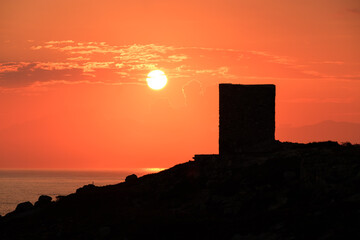 Fototapeta na wymiar Sun rising behind genoese tower in Corsica