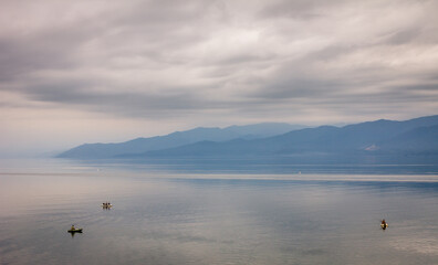 Cloudy landscape of Baikal lake, Irkutsk region, Russia, near Kultuk village, fisherman boats