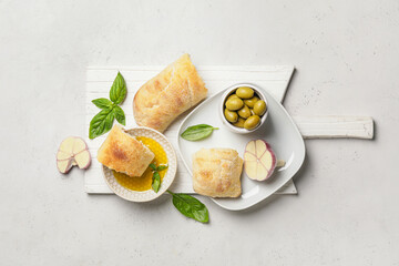 Bowl of tasty olive oil and bread on white background