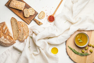 Composition with tasty olive oil and bread on white background