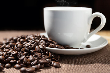 Coffee beans and a cup of coffee on a sackcloth