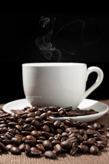 Coffee beans and a cup of coffee on a sackcloth