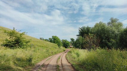 Fototapeta na wymiar road near a green slope against a blue sky
