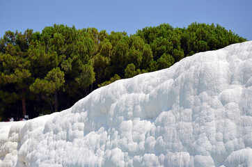 Travertine terraces against forest and sky