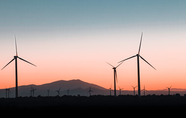 Blue hour with mills and renewable energy with mountains